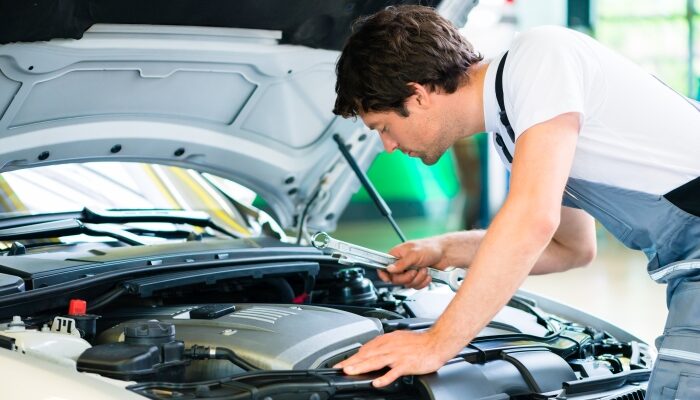 Мужчина осматривает двигатель